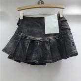 Black denim skirt on a hanger against a white background